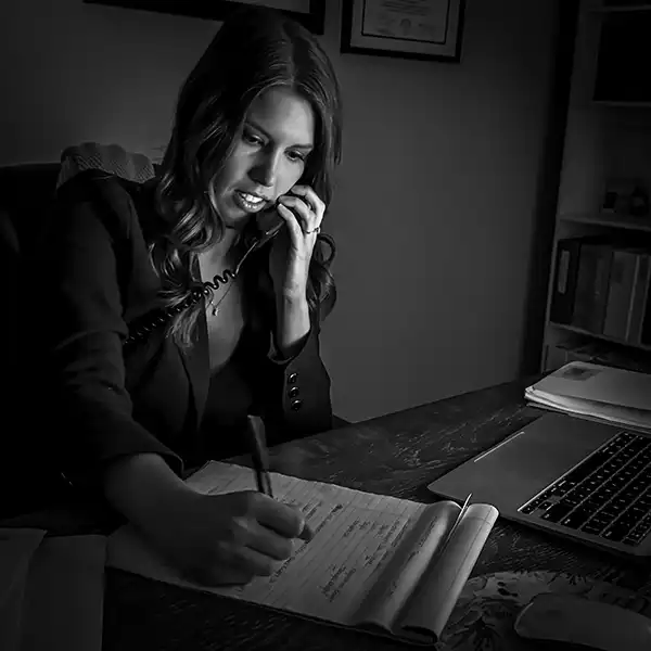 Attorney Kendall “Micaelah” Gale speaking on the phone while taking notes at her desk in the Shingler Law office<br />
